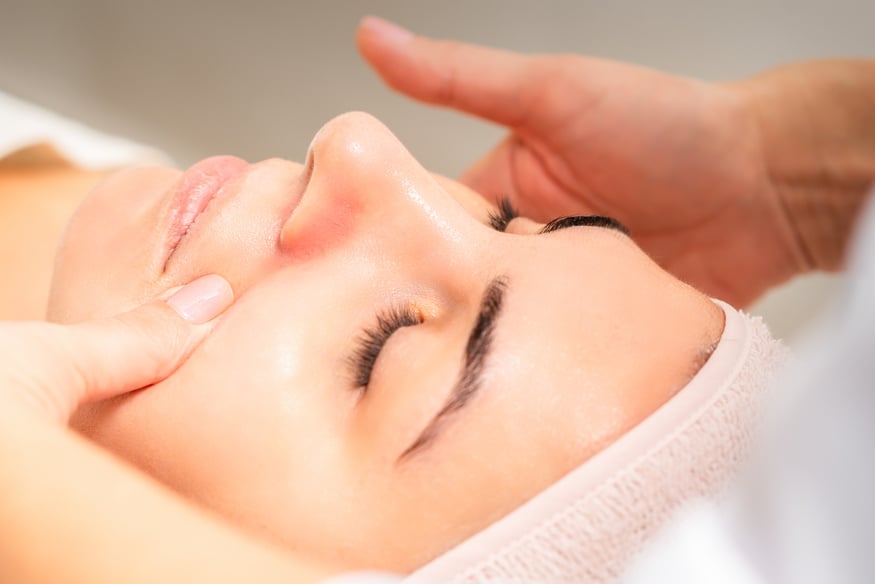 Beautician Making Lymphatic Drainage Face Massage or Facelifting Massage at the Beauty Salon.